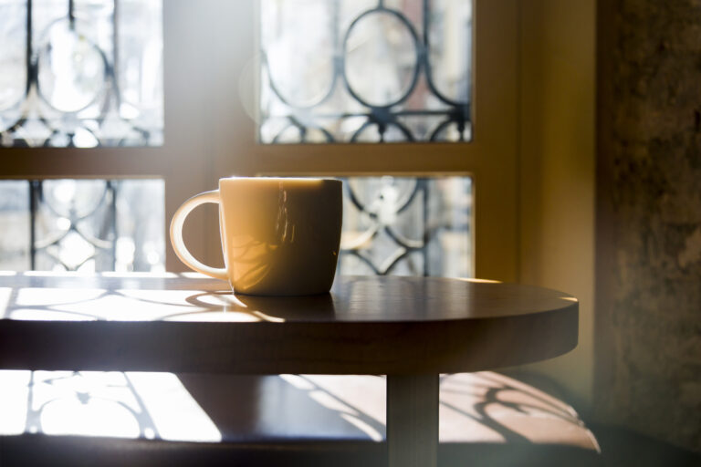 A quiet sunrise scene with coffee by a window, symbolizing God's sustaining grace received each morning