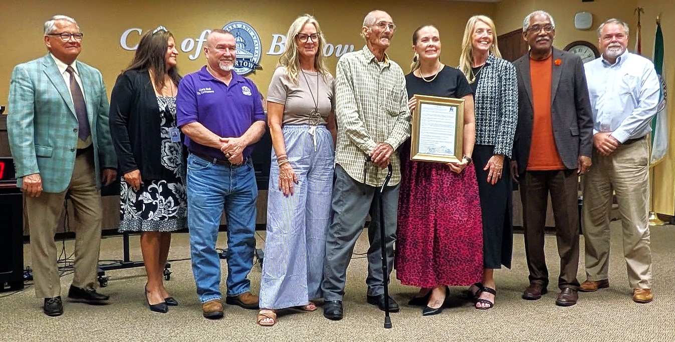 For half a century, Gerald Cochran has been an active participant at city commission meetings, as well as having been a candidate. Whether holding officials' feet to the fire or, upon occasion, complimenting them, he has demonstrated what it means to take an active role in the community. Standing with Cochran (center, holding onto a cane) are (from left:) City Manager Mike Herr, City Clerk Jacki Poole, Commissioners Gary Ball, Trish Pfeiffer, Mayor Tanya Tucker, Commissioners Laura Simpson, Leo Longworth, and City Attorney Sean Parker