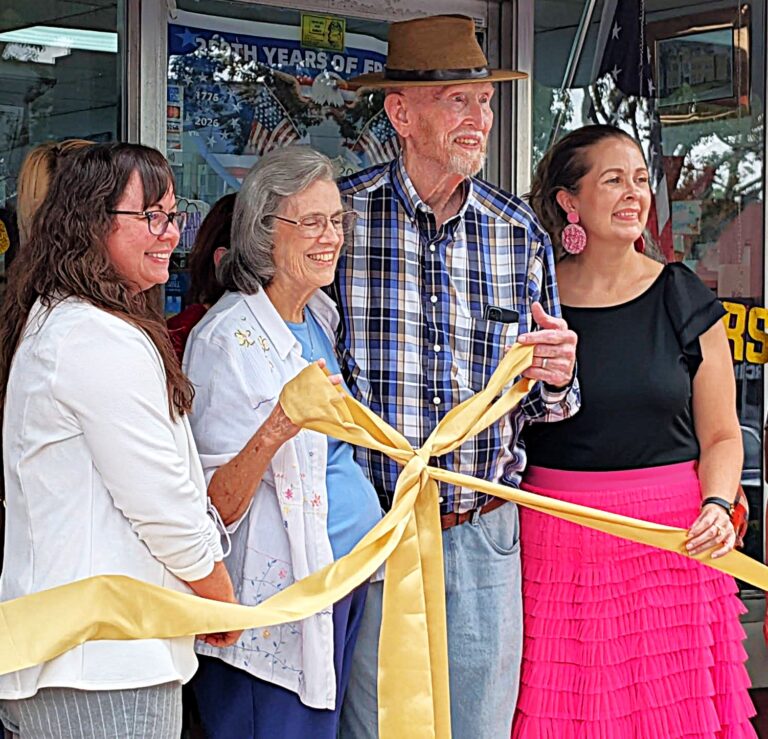 Greater Bartow Chamber of Commerce Executive Director Michelle Helms, Sandy and Bo Raulerson, and Mayor Tanya Tucker hold up a ribbon bow outside Bartow Christian Books and Gifts on East Main Street.