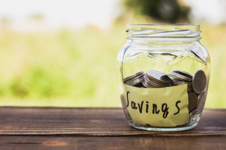 jar of coins on wooden table